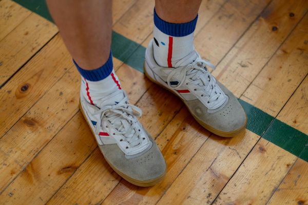 Close up of sports sneakers on a dark wooden floor gym